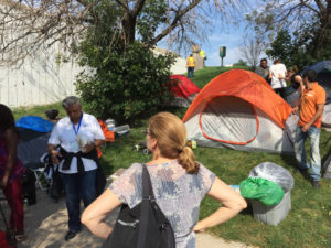 Law Project Director Patricia Nix-Hodes monitors the city's actions. The city made homeless people move their tents and belongings for a few hours Friday while city crews tossed any junk left behind before sweeping and power-washing the sidewalks.| Mark Brown / Sun-Times