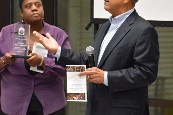 Alderman Maldonado accepts the John Donahue Award from leader Edrika Fulford.