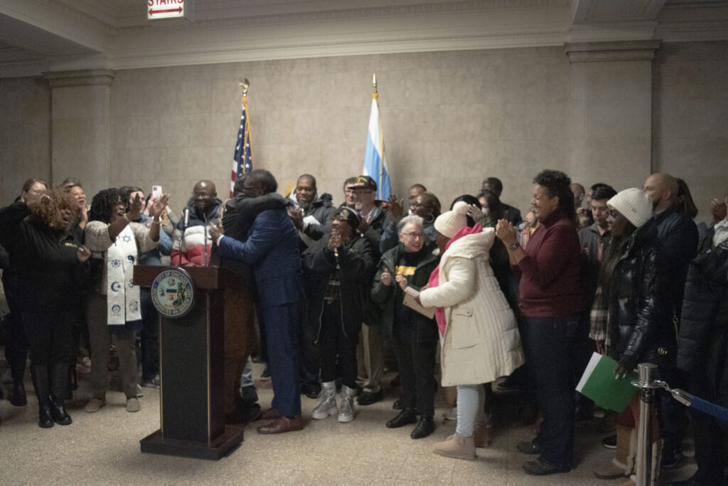 El alcalde Brandon Johnson y otros simpatizantes del BCH celebran juntos en el Ayuntamiento de Chicago.