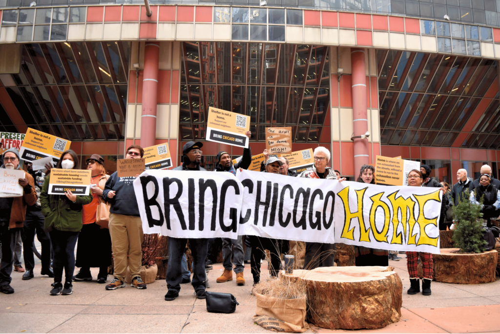 A group of protestors holds up a banner saying "Bring Chicago Home."
