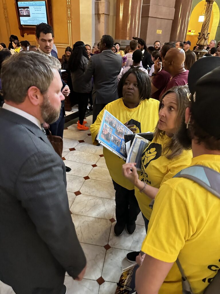 Un grupo de líderes de CCH presionando al Rep. Harry Benton