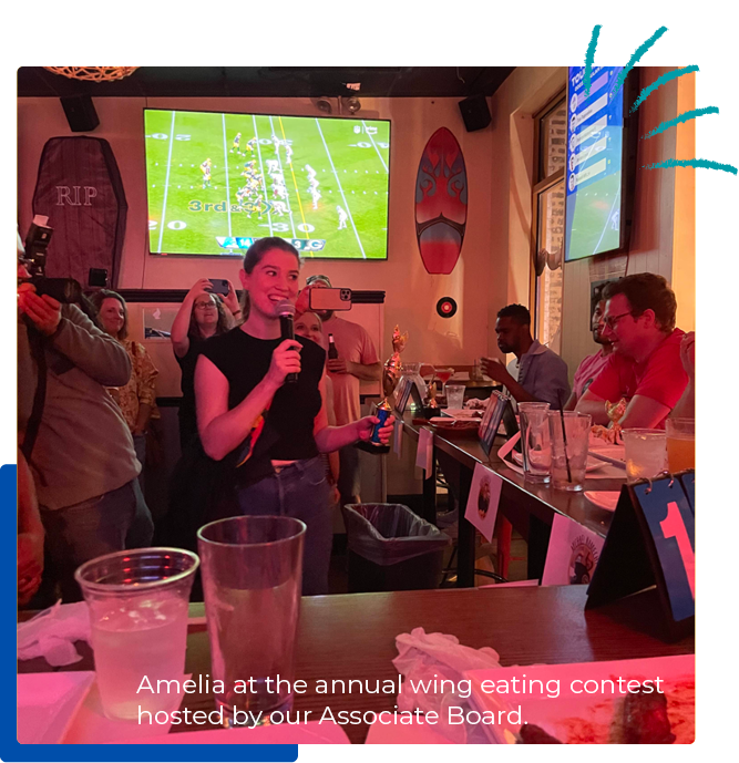 A person is holding a microphone and a trophy and standing behind a bar.