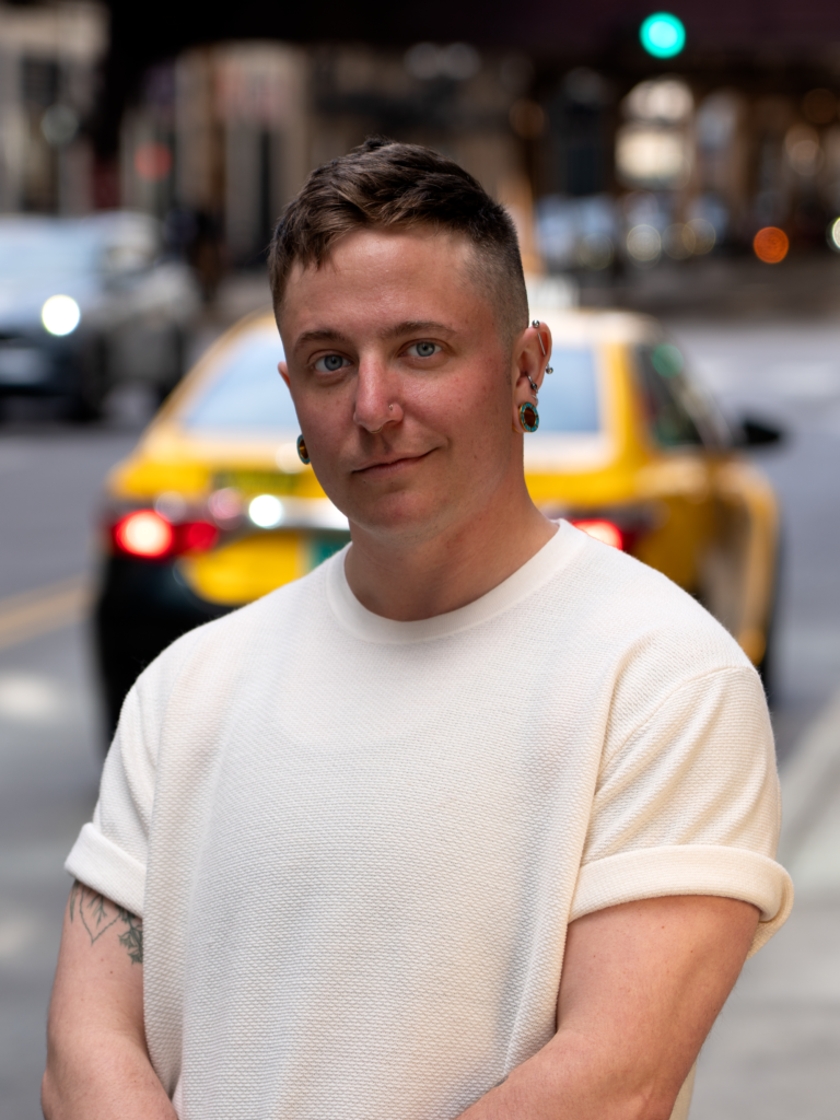 A person stands on a Chicago Street with a cab behind them.